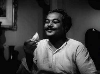 The zamindar pigs out behind Nirmal's back The zamindar pigs out behind Nirmal's back