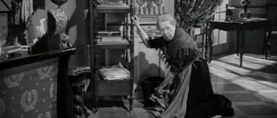 A cleaning lady finds something in a bin