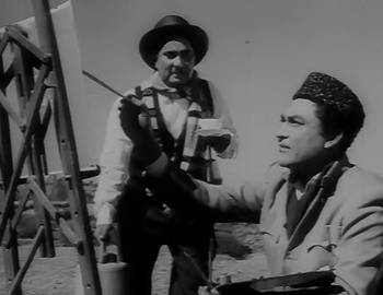 Amar makes a painting, watched by D'Souza