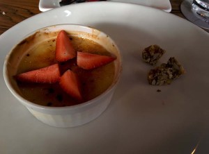 Classic vanilla creme brulee, served with praline and a quartered strawberry.