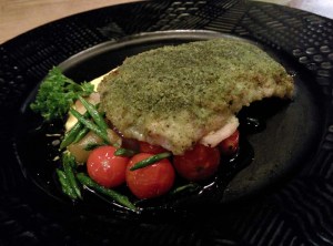 Herb crusted fish on a bed of sweet button onions, diced potatoes, and cherry tomatoes.