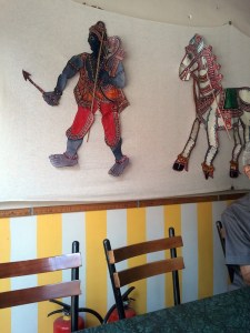 Leather puppets on a wall at Carnatic Cafe.