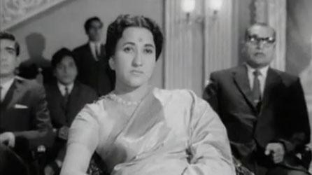 ... while an unsmiling Sharda looks on