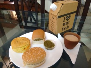 An array of snacks: keema pav (with some green chutney on the side), bun maska, bun bhujia - and a kulhad of chai.