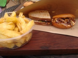 Two types of sandwich, with fries.