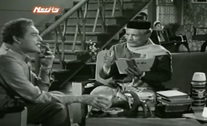 The Major's hand touches the glass of water