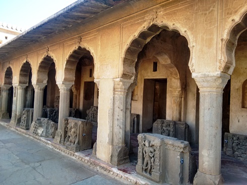 The colonnade at Chand Baori, with an array of sculptures on display.